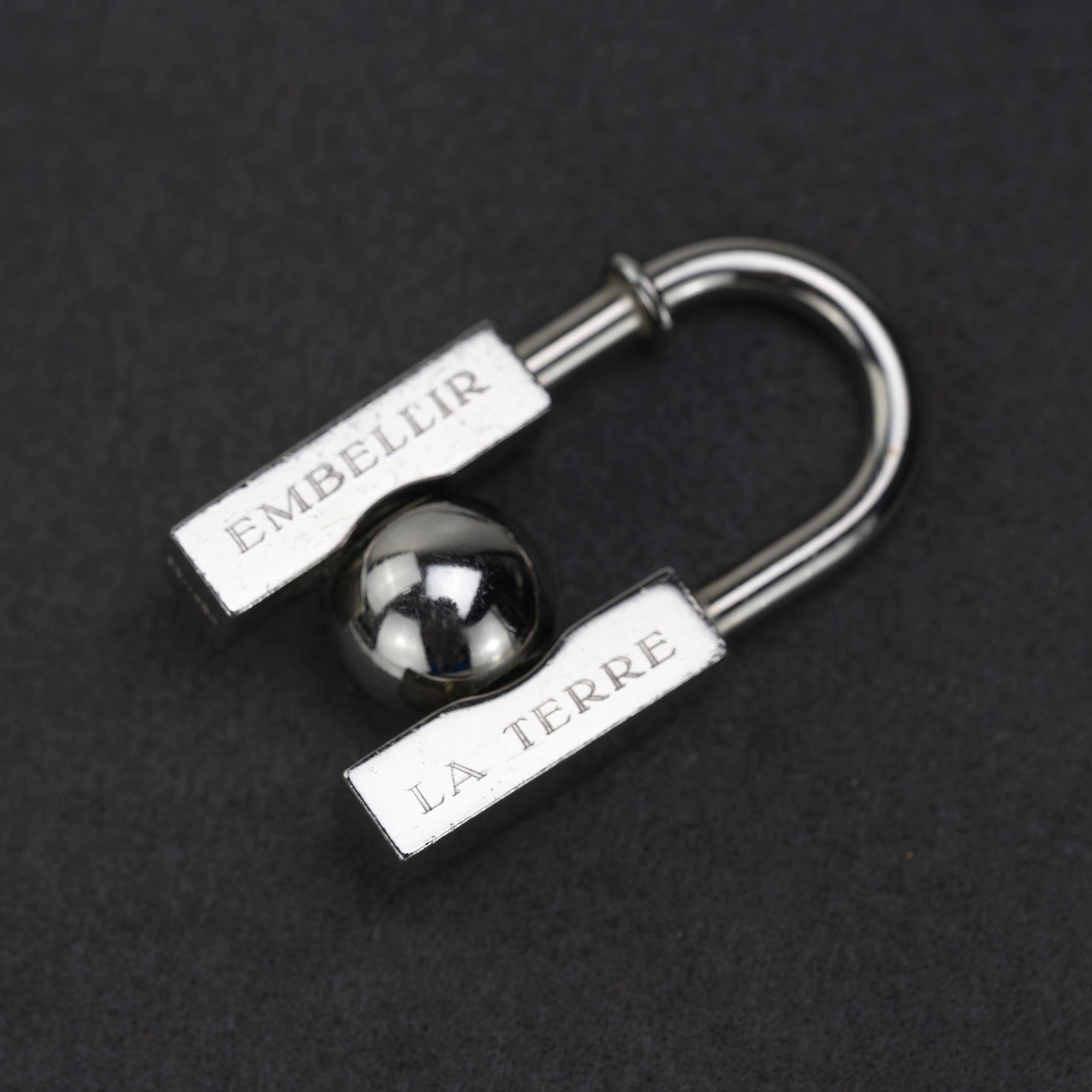 HERMES Padlock Charm 2001 Limited Edition "L'HOMME PEUT EMBELLIR LA TERRE/In Search of the Unknown Beauty of the Earth"