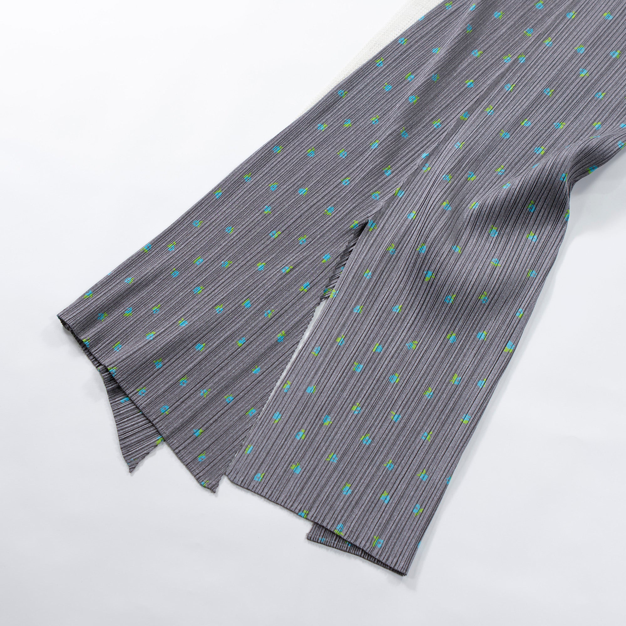 Used PLEATS PLEASE ISSEY MIYAKE side-slit skirt in gray with a floral print. Women's bottoms.
