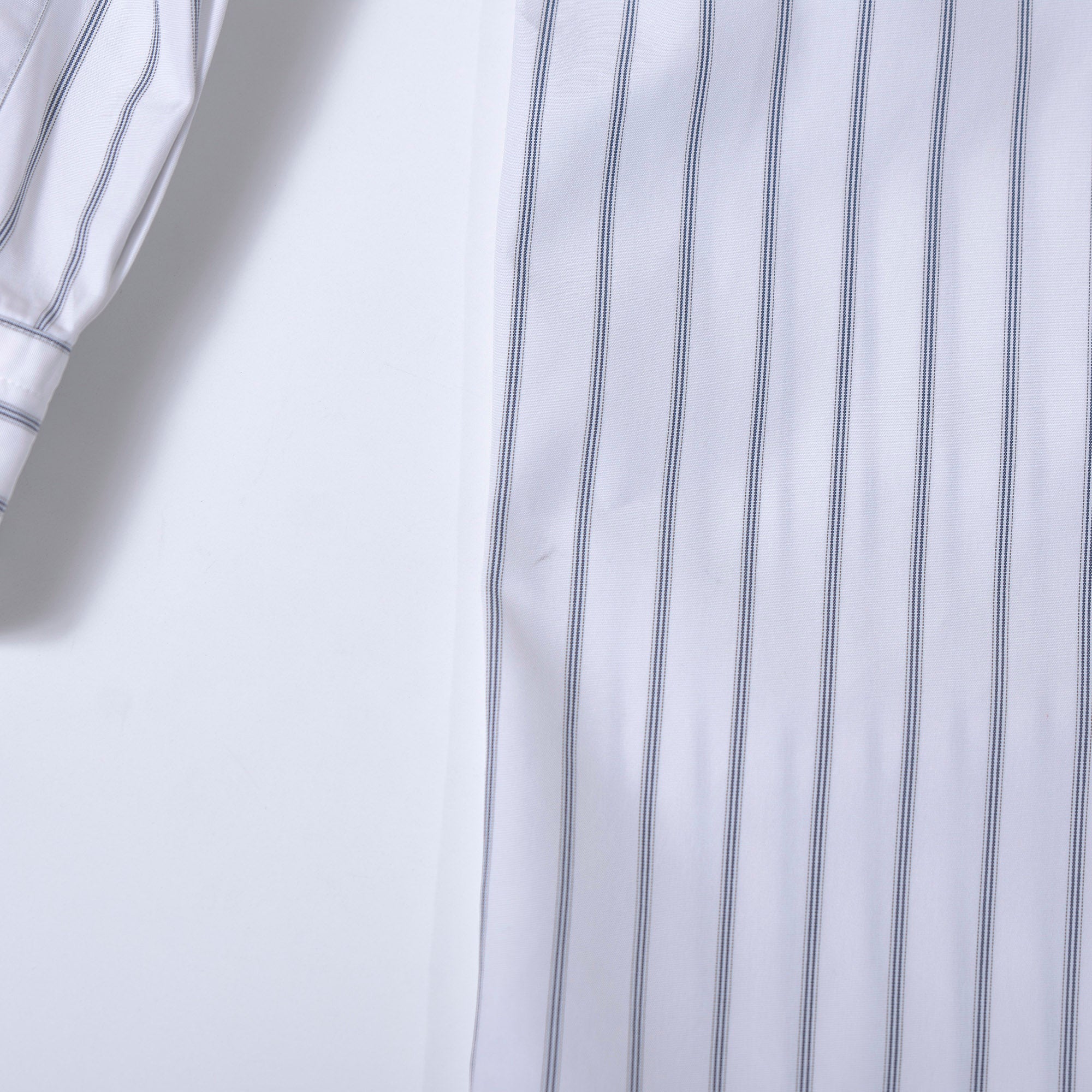Comme des Garçons striped shirt with a boxy silhouette and long sleeves. This 90s white shirt features an open collar and is designed by Keiichi Tanaka of Tanaka Homme.