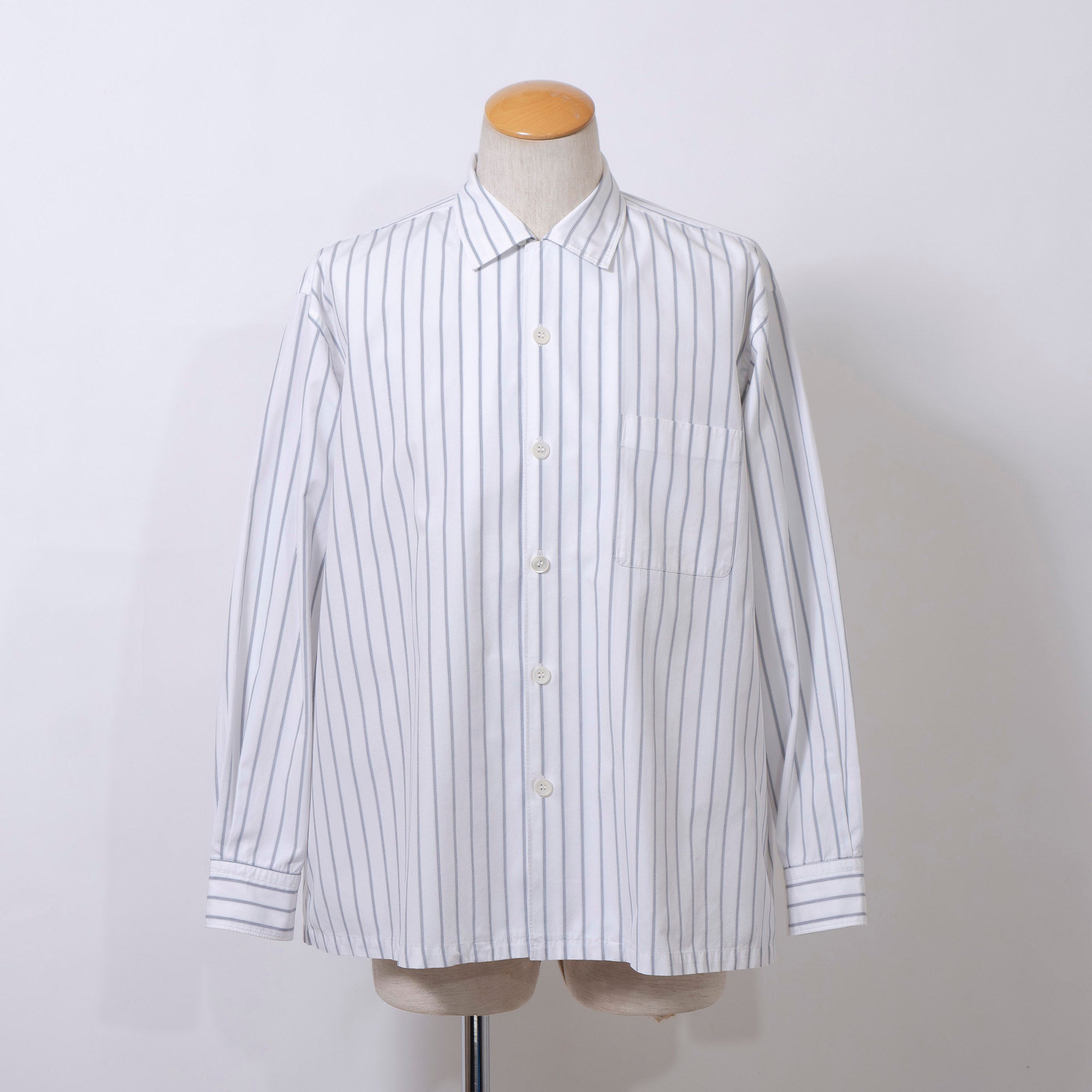 Comme des Garçons striped shirt with a boxy silhouette and long sleeves. This 90s white shirt features an open collar and is designed by Keiichi Tanaka of Tanaka Homme.