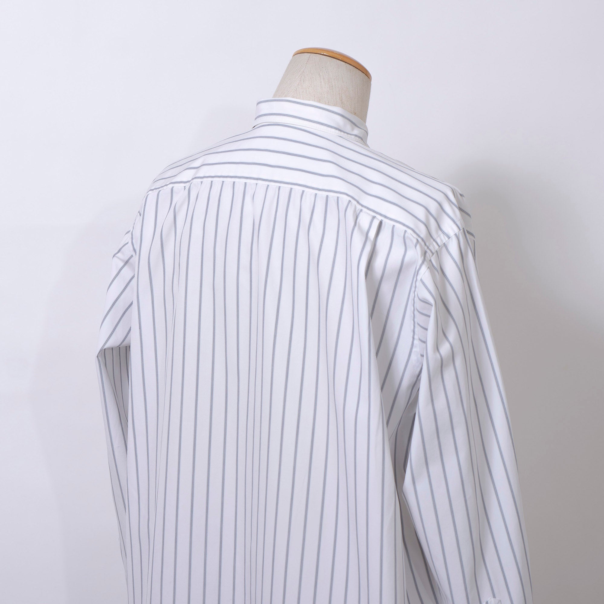 Comme des Garçons striped shirt with a boxy silhouette and long sleeves. This 90s white shirt features an open collar and is designed by Keiichi Tanaka of Tanaka Homme.