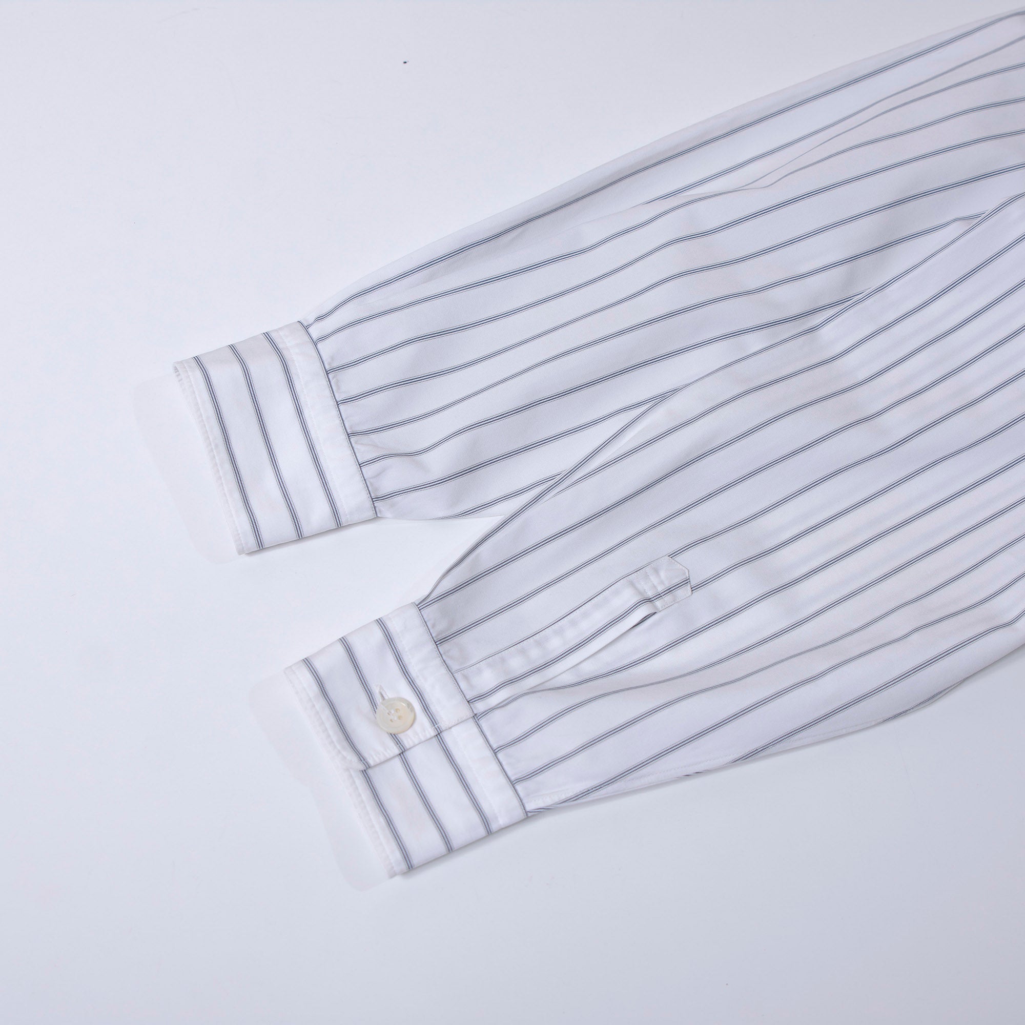 Comme des Garçons striped shirt with a boxy silhouette and long sleeves. This 90s white shirt features an open collar and is designed by Keiichi Tanaka of Tanaka Homme.
