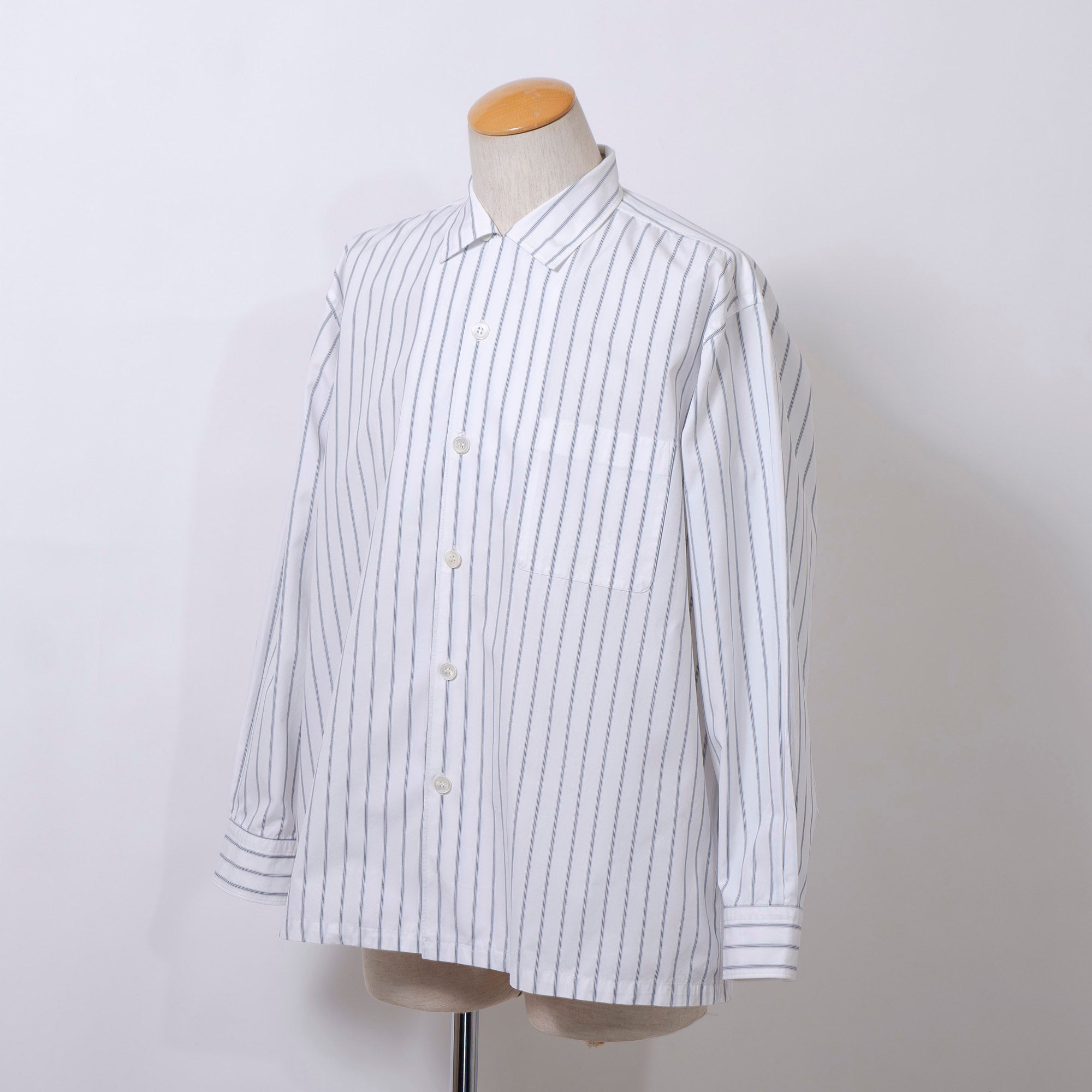 Comme des Garçons striped shirt with a boxy silhouette and long sleeves. This 90s white shirt features an open collar and is designed by Keiichi Tanaka of Tanaka Homme.